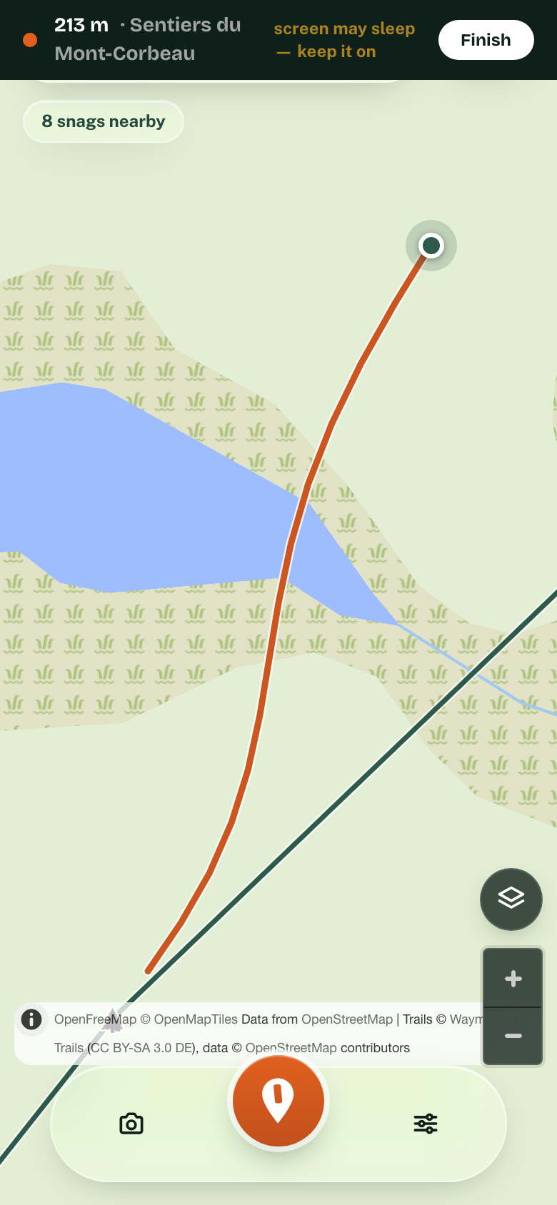 A phone recording a walk: 213 m captured, the orange line following the trail, and the warning to keep the screen on.
