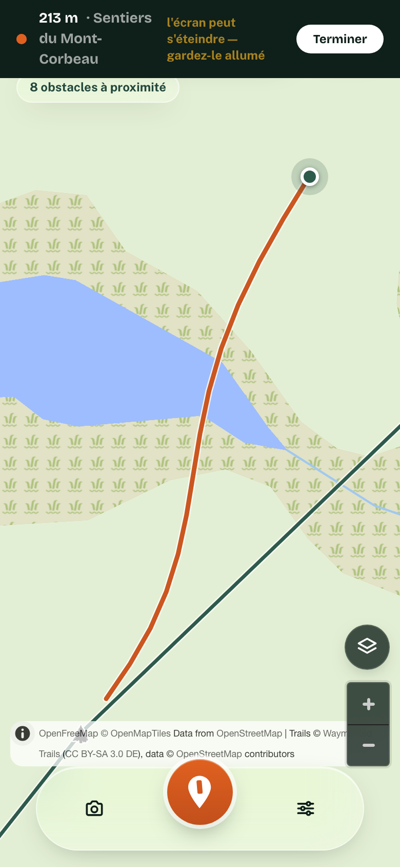 Un téléphone en train d’enregistrer une marche : 213 m captés, le tracé en orange qui suit le sentier, et l’avertissement de garder l’écran allumé.